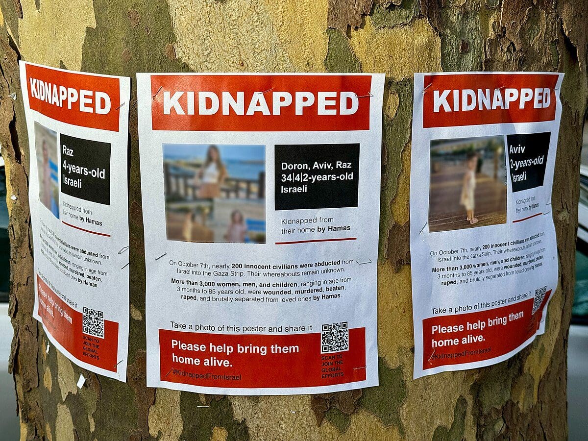 Talci Izrael Wikimedia Oleg Yunakov https://commons.wikimedia.org/wiki/File:Posters_of_hostages_taken_by_Hamas_during_the_2023_attack_on_Israel.jpg