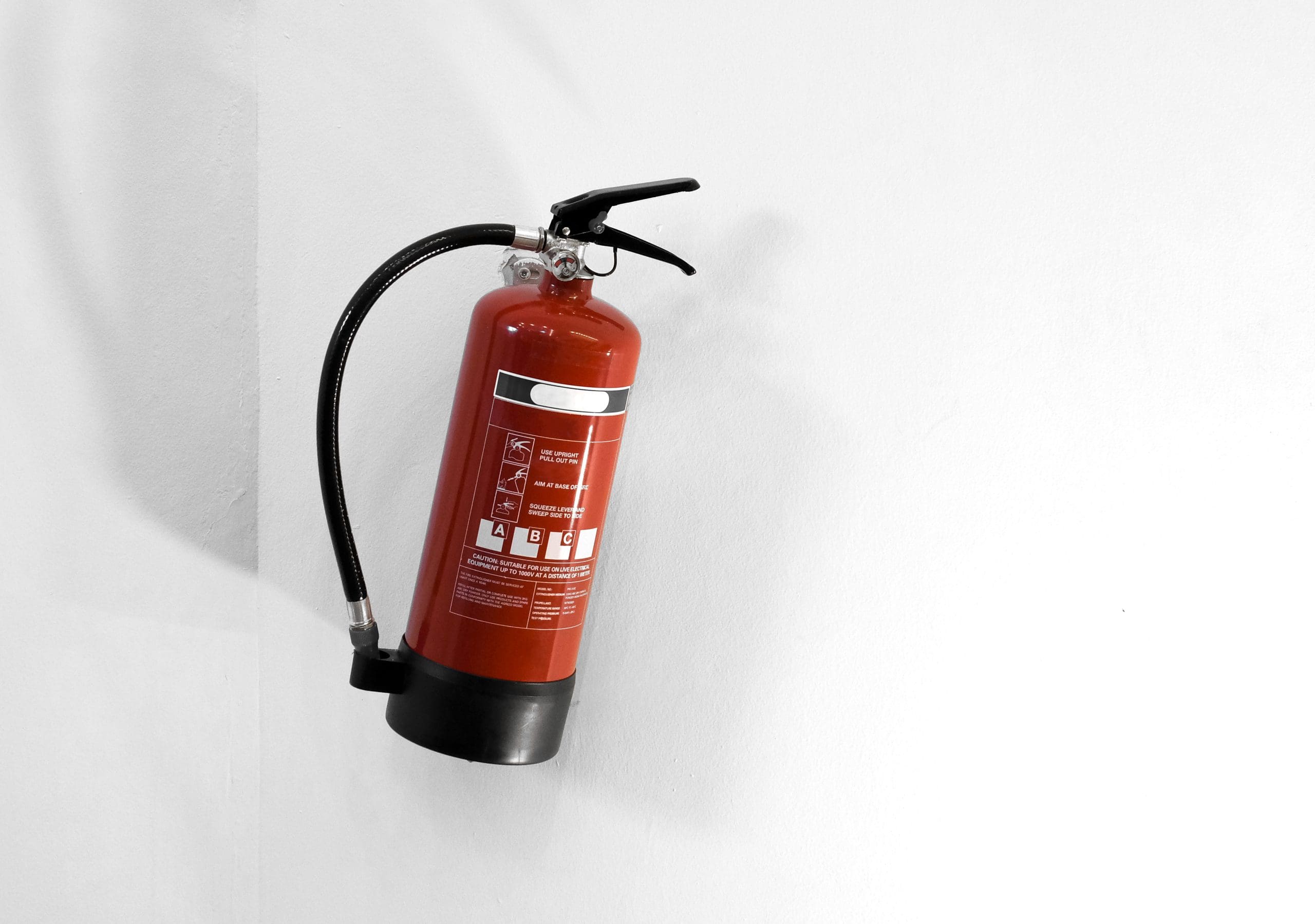 Red fire extinguisher on a white wall https://www.freepik.com/free-photo/red-fire-extinguisher-white-wall_15004842.htm#fromView=search&page=1&position=4&uuid=a2de3c0b-9cc5-4512-856c-b75cb676adc2&query=+fire+extinguisher